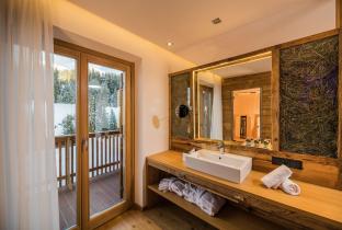 The open bathroom of the room Sella Relax with sink and access to the balcony