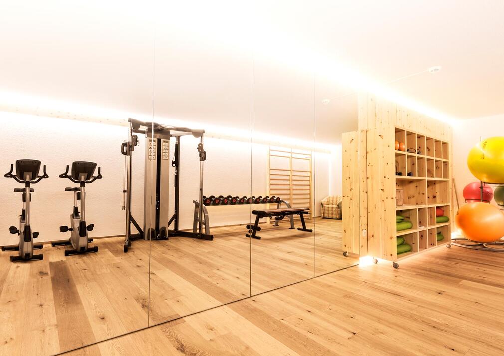 Fitnessbereich im Sporthotel Floralpina mit Cardiogeräten, Hanteln und Trainingszubehör