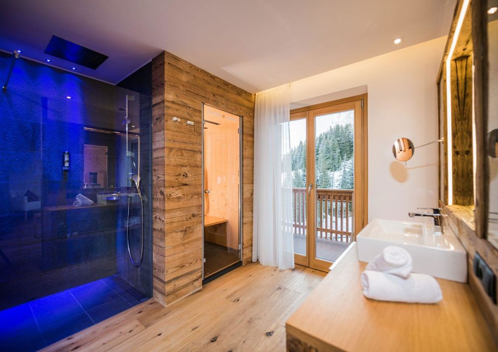 Das Badezimmer des Doppelzimmers Sella Relax mit Infrarotkabine, Regendusche, Waschtisch und Balkon