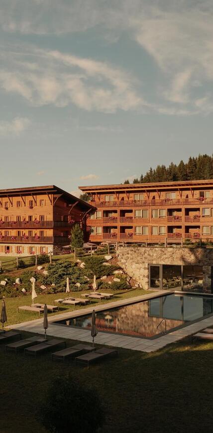 Vista esterna dello Sporthotel Floralpina sull'Alpe di Siusi con piscina all'aperto e vista Dolomiti