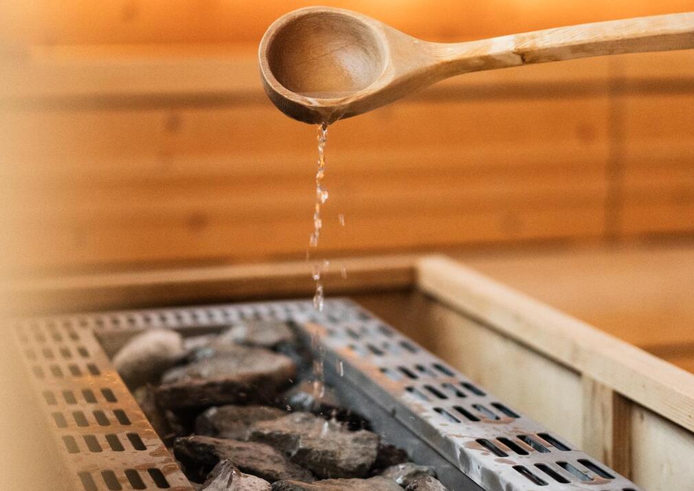 Saunaaufguss in der finnischen Sauna des Wellnesshotels Floralpina auf der Seiser Alm