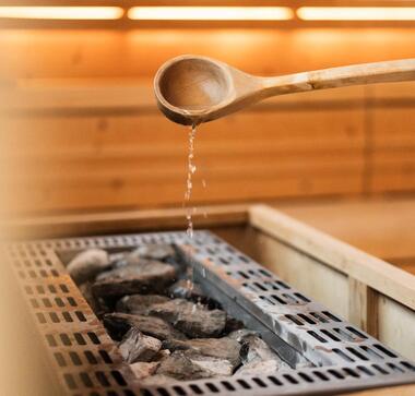 Saunaaufguss in der finnischen Sauna des Wellnesshotels Floralpina auf der Seiser Alm