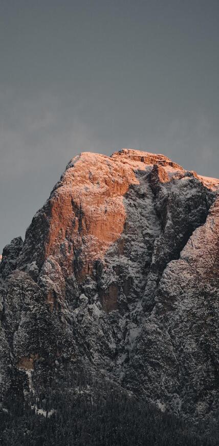Verschneite Dolomitengipfel im warmen Abendlicht in Südtirol